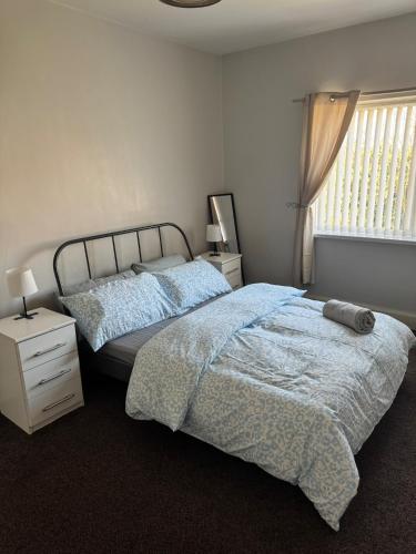 a bedroom with a large bed and a window at Spacious 2 bedroom flat in Newcastle w Free parking in Kenton