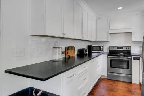 Una cocina con gabinetes blancos y una encimera negra. en Sandcrab Court 18 by Wild Dunes, with Amenities, en Isle of Palms