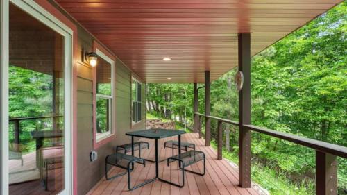 a screened porch with a table and chairs on it at 5 Pines on Ossie by Woods to Water in Breezy Point