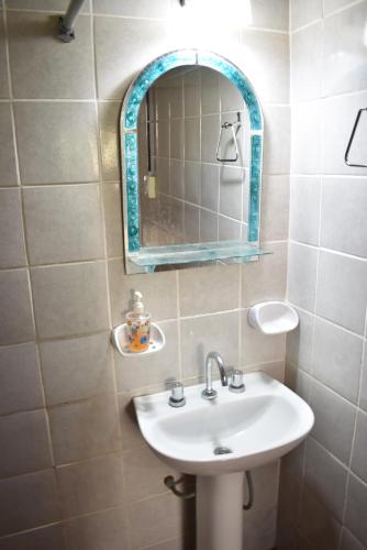 a bathroom with a sink and a mirror at Sampa Pacha Complejo de Cabañas in Bialet Massé