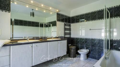 La salle de bains est pourvue de 2 lavabos, de toilettes et d'une douche. dans l'établissement CORNOUAILLE house 6 p close to Concarneau beach, à Concarneau