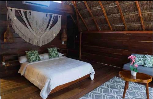 a bedroom with a bed and a wooden wall at Nido BY puerto morelos in Puerto Morelos