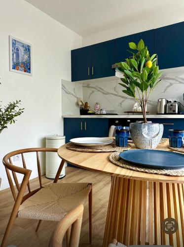 une cuisine avec des placards bleus et une table en bois dans l'établissement La Grèce - Appartement chaleureux en hypercentre, à Saint-Quentin