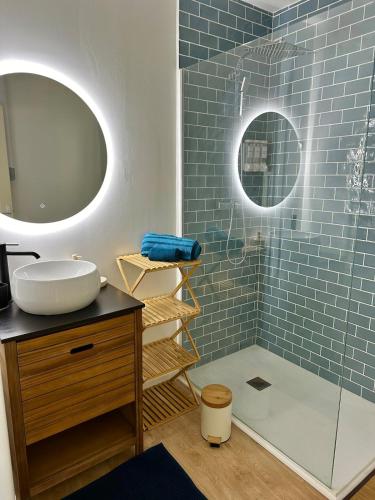 une salle de bain avec un lavabo et un miroir dans l'établissement La Grèce - Appartement chaleureux en hypercentre, à Saint-Quentin