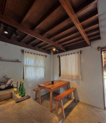 a dining room with a wooden table and benches at Siargao Nalu Loft House in Burgos