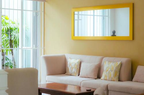 a living room with a couch and a mirror at Spacious Eco Guest House Colombo in Sri Jayewardenepura Kotte