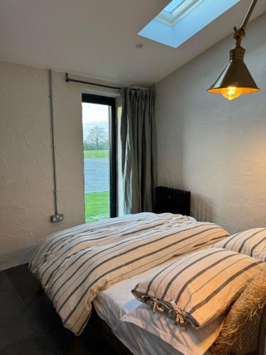 ein Schlafzimmer mit einem großen Bett mit Fenster in der Unterkunft The Old Sty in Canterbury