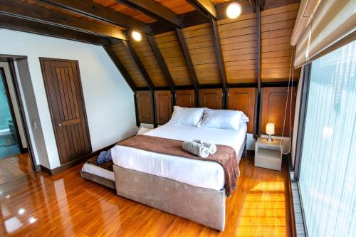 ボゴタにあるChalet Suizo, BBQ, Chimney -Luxury Stayの木製の壁のベッドルーム1室(大型ベッド1台付)