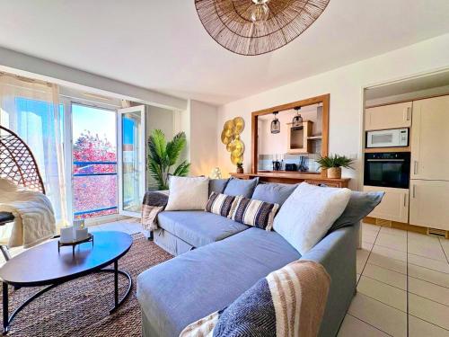 a living room with a blue couch and a table at Magnifique 2 chambres - Parking - Netflix - Gare in Arras