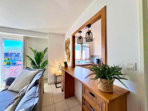 Cette chambre comprend un bureau avec un miroir et un canapé. dans l'établissement Magnifique 2 chambres - Parking - Netflix - Gare, à Arras