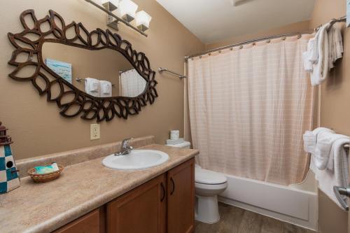 a bathroom with a sink and a toilet and a mirror at Ocean Terrace Condominiums in Lincoln City