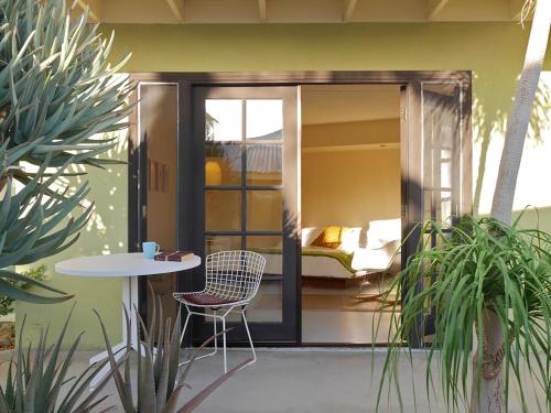 a patio with a table and a bed in a room at Hope Springs Resort in Desert Hot Springs