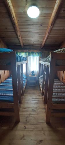 a room with three bunk beds in a cabin at Murmullos del bosque in Lago Puelo
