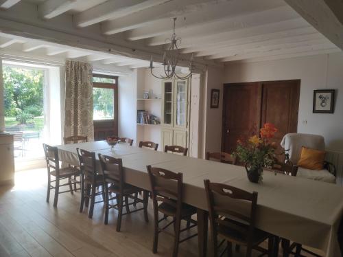 une salle à manger avec une grande table et des chaises dans l'établissement Ferme de la Motte, à Le Mesnil-Gilbert
