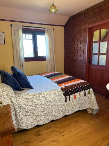 a bedroom with a bed with a blanket on it at La casa Florencia in Puerto Varas