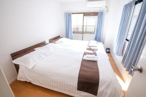 a bedroom with a bed with two towels on it at Mitomi inn 京急蒲田駅 in Tokyo