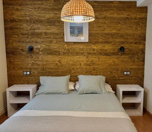 a bedroom with a bed with two night stands at Apartamentos Turísticos Casa Nieves in La Franca