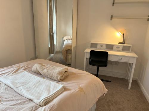 a bedroom with a bed with a desk and a chair at En-suite double room on riverside of Canada Water in London