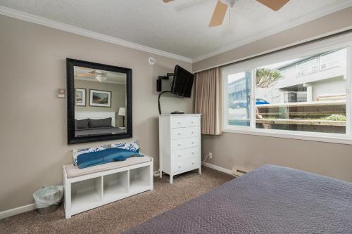 a bedroom with a bed and a mirror and a dresser at Ocean Terrace Condominiums in Lincoln City