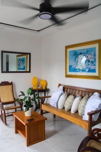 Habitación con 2 bancos de madera y almohadas. en Acogedor apartamento a cerca de la playa, en San Felipe de Puerto Plata