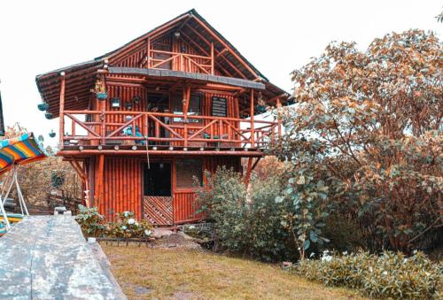 a large wooden house with a balcony on it at Cabaña El Rosario in Santa Elena