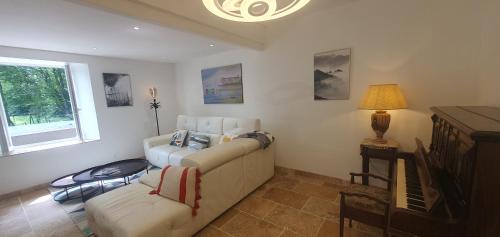 un salon avec un canapé et une télévision dans l'établissement Maison familiale Baylère - Piscine et spa - 8 pers, à Buzy