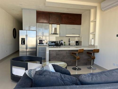 ein Wohnzimmer mit Couch und Küche in der Unterkunft Pelicanos Residencial in Puerto Peñasco