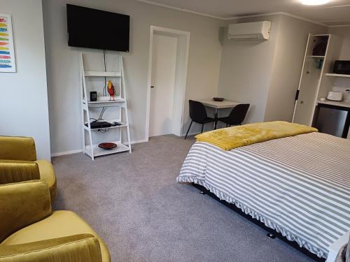 a bedroom with a bed and a chair and a table at Rotorua Studio in Rotorua