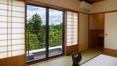 a room with a window with a view of the forest at Hayataro Onsen Komagane Kogen Retreat Suzuran Haya - Vacation STAY 34206v in Komagane