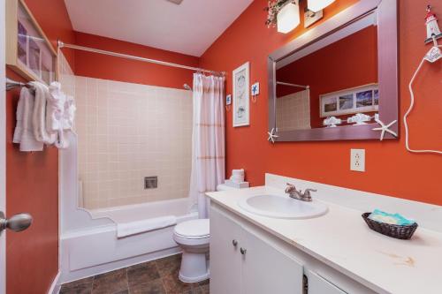 a bathroom with a sink and a toilet and a mirror at Ocean Terrace Condominiums in Lincoln City