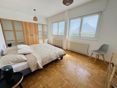 une chambre avec un lit, une chaise et des fenêtres dans l'établissement La Joliette, maison 5 chambres, à Rumegies