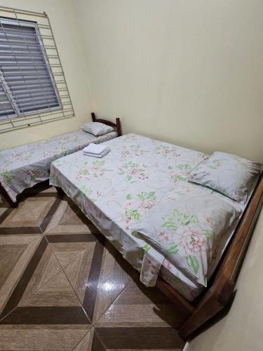 a bed sitting in a room with a window at Pousada Amigu's in Pontal do Paraná