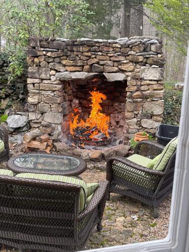 a stone fireplace with two chairs and a fire pit at A Mammoth Cave Getaway in Park City