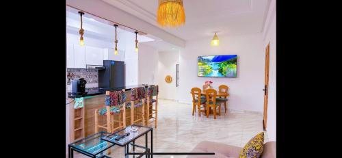 a kitchen and living room with a table and chairs at Appartement Cosy moderne, UScuisine in Oulad Hammou