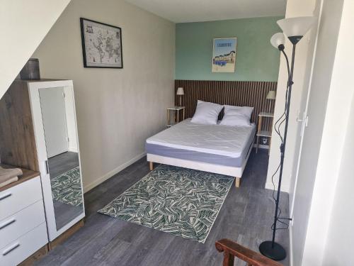 - une petite chambre avec un lit et un tapis dans l'établissement Duplex pour escapade en Normandie, à Merville-Franceville-Plage