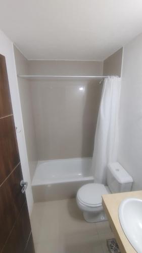a white bathroom with a toilet and a sink at Franco l in Posadas