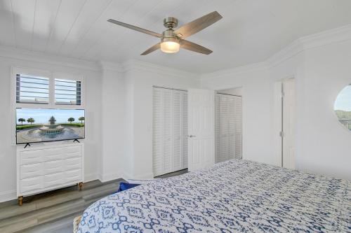 a white bedroom with a bed and a ceiling fan at Shipwatch 308B by Wild Dunes, Oceanfront Condo with Resort Amenity Access in Isle of Palms