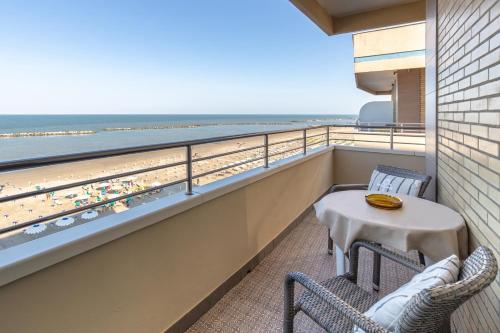a balcony with a table and chairs and the beach at Hotel Bamby e Delfino in Gatteo a Mare