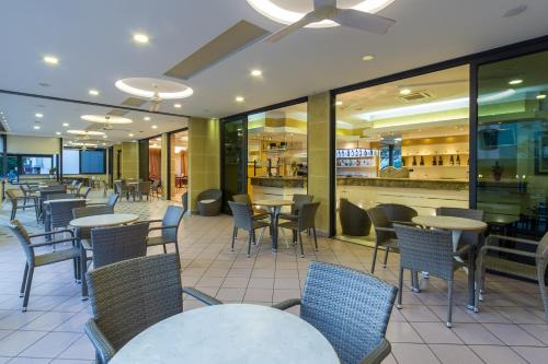a restaurant with tables and chairs and a bar at Hotel Bamby e Delfino in Gatteo a Mare