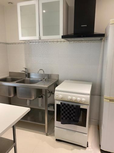 une cuisine avec un évier et une cuisinière dans l'établissement Spacious home and its gym, à Les Alluets-le-Roi