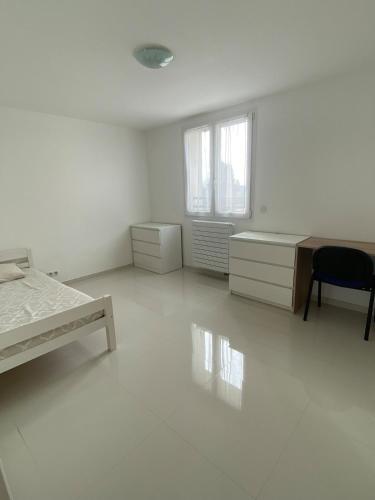 Cette chambre blanche dispose d'un bureau et d'une chaise. dans l'établissement Spacious home and its gym, à Les Alluets-le-Roi