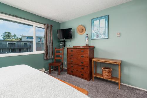 a bedroom with a bed and a dresser and a window at Ocean Terrace Condominiums in Lincoln City