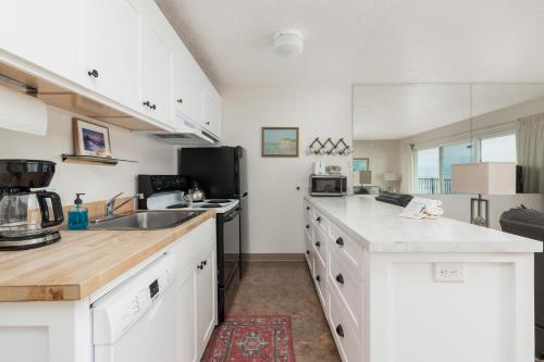 a kitchen with white cabinets and a counter top at Ocean Terrace Condominiums in Lincoln City