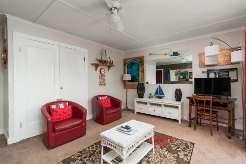 a living room with two red chairs and a table at Ocean Terrace Condominiums in Lincoln City