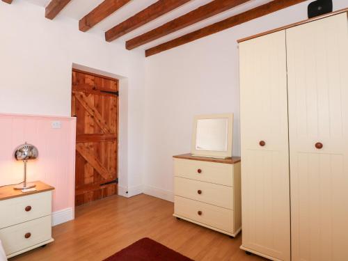 a room with a closet and a dresser and a door at Hafod in Llanllyfni