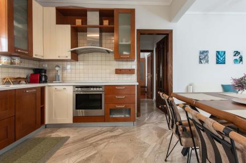 a kitchen with wooden cabinets and a table with chairs at My House in Thessaloniki