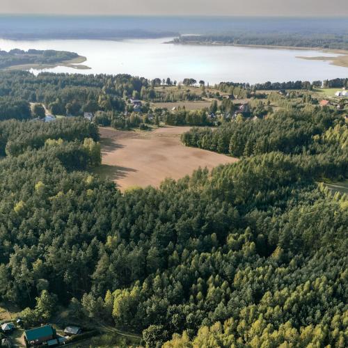 an aerial view of a field and a lake at Ostoja Wycinki domki letniskowe in Jaszczerz