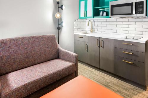 a living room with a couch and a sink at Big Country Hotel & Suites, SureStay Collection by BW in Abilene