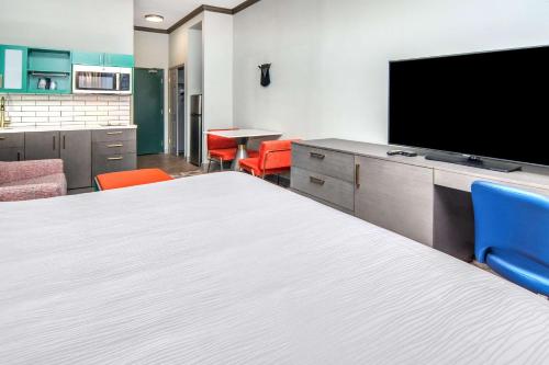 a hotel room with a bed and a flat screen tv at Big Country Hotel & Suites, SureStay Collection by BW in Abilene