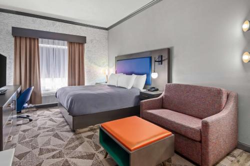a hotel room with a bed and a chair at Big Country Hotel & Suites, SureStay Collection by BW in Abilene